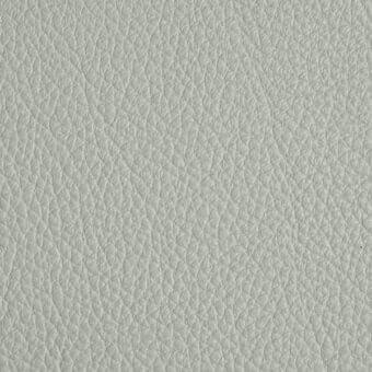 Light gray leather texture sample displaying a granular grain, with “arketipo” label, against a white backdrop, studio lighting.