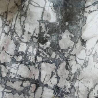 Moon Grey marble surface displaying dark grey and black veining across a white background, with pinkish-grey tonal variations and a matte finish.