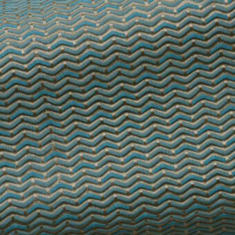 Geometric teal and beige woven fabric pattern with repeating wave-like rectangular blocks, displaying a subtle sheen and uniform texture.