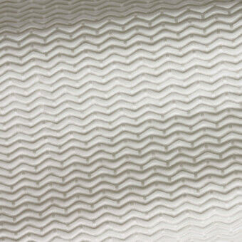Chevron fabric sample in sand mixture tones displays a woven texture with subtle sheen and repeating V-shaped pattern throughout the frame.