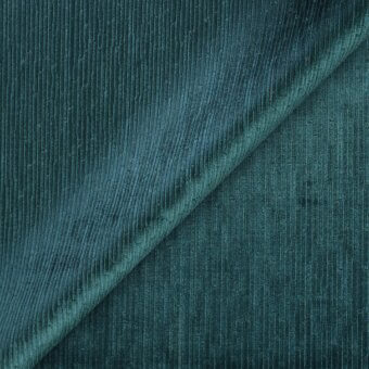 Teal corduroy fabric swatch, diagonally folded, displays vertical ribbing and a matte texture, with darker shadowed areas and lighter ridges.