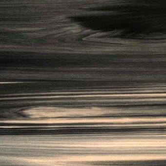 Wood grain texture with horizontal layering in gray, black, and beige tones, matte finish, subtle curved strokes, brand text at the bottom right.