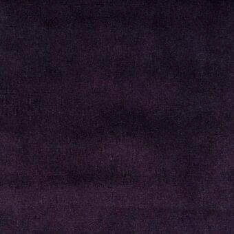 Purple fabric texture with a dense, velvety pile and matte finish, displaying subtle tonal variations and a granular surface.