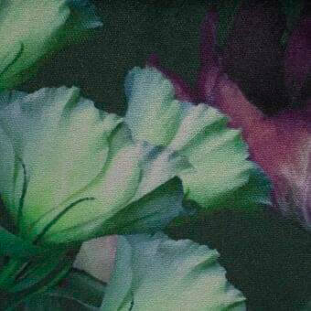 Floral fabric pattern in muted greens, whites, and reddish-purple with layered petals, woven texture, dark green background.