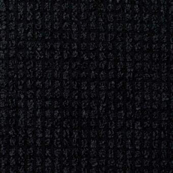 Dark woven fabric texture displays a dense, repetitive pattern of small, abstract shapes in monochromatic tones with subtle depth.