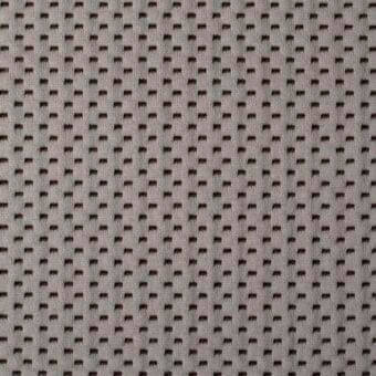 Bonaldo fabric sample “cookie” (SP39), gray knit with repeating dark brown bow-tie perforations in a grid pattern, subtle sheen.