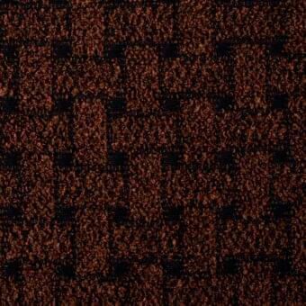 Rust-brown woven textile with a repeating grid of dark squares, exhibiting a dense looped pile and rough, shaggy texture.