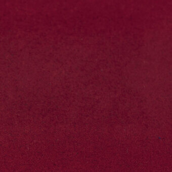 Red fabric texture with a matte finish and tight weave, displaying subtle tonal variations and a granular surface for rich depth.