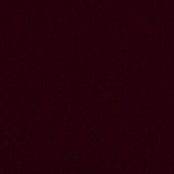 Burgundy velvet fabric with a directional nap and matte finish, displaying a uniform, saturated red-purple tone and plush texture.