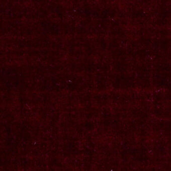 Red velvet fabric with a short, dense pile and mottled texture, displaying a rich crimson and burgundy color palette under even lighting.