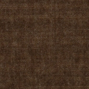 Dark brown velvet fabric texture with mottled tonal variations and a short, dense pile; embossed weave, brand label visible.