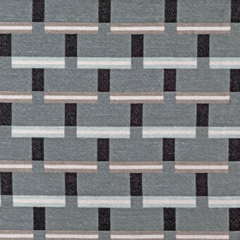 Geometric textile pattern in muted gray, light blue, beige, and dark gray, featuring interlocking rectangular blocks in a grid arrangement.