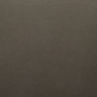 Textured brown fabric surface with a matte finish and granular weave, appearing as leather or a leather-like textile with consistent coloration.