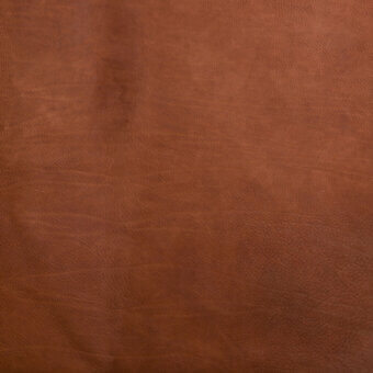 Brown vegetable-tanned leather texture with a pebbled grain, matte finish, and imprinted “borzalino” label detailing tanning process.