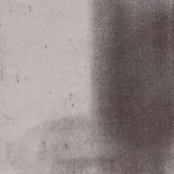 Textured gray surface divided vertically, light gray grainy left, dark charcoal scratched right, porous granular quality, diffused lighting.