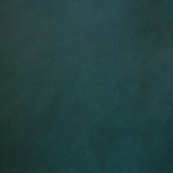 Vegetable-tanned leather surface, deep teal color, fine grain texture with mottled variations, matte finish, soft diffused lighting.