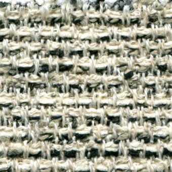 Woven tweed fabric, off-white and black, displays a vertical-horizontal thread pattern with a nubby texture and subtle grid structure.