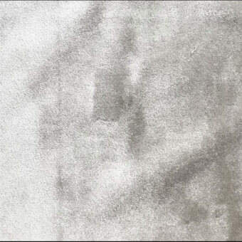 Light gray stucco texture with granular surface, displaying dark gray blotches and streaks, creating a matte, neutral, and aged composition.