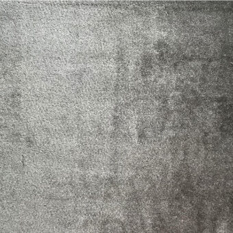 Gray pile velvet fabric with a dense, short nap and mottled texture; cool-toned variations create a subtly distressed appearance.