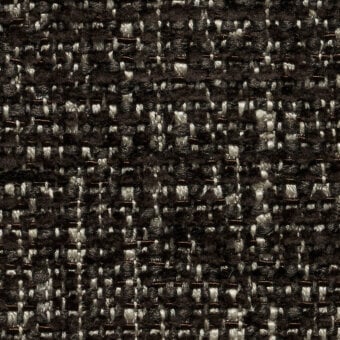 Woven tweed fabric, dark brown and off-white, dense irregular pattern with visible fibers and matte finish, labeled “lucinasco” textile.
