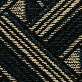 Geometric fabric sample, dark blue and cream, features diagonal stripes, looped pile, and triangular woven patches, matte finish.