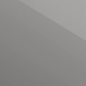 Polished chrome metal surface angled diagonally, exhibiting smooth reflectivity and tonal variations in cool gray with highlighted shadows.