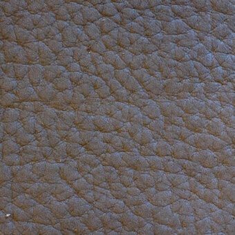 Dark brown nubuck leather texture with a dense, irregular bumpy pattern and subtle diagonal linear markings, matte finish.