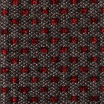 Charcoal gray fabric swatch with small red circular motifs, textured nubby weave, studio lighting, reference code m72.