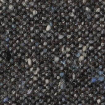 Dark charcoal gray tweed fabric texture, n04 Constantini Pietro collection, with flecks of gray, cream, blue, and brown fibers.
