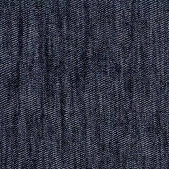 Dark indigo denim fabric texture with a tight, diagonal rib weave and subtle heathered tonal variations, suggesting durability.