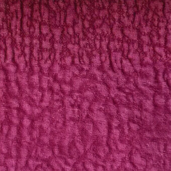 Burgundy textile with a repeating raised scale pattern, woven fabric texture displaying a three-dimensional surface and slight sheen, egoitaliano sample.