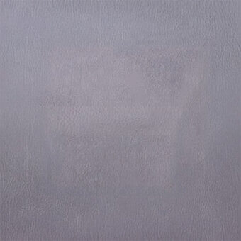 Muted gray-purple textured surface with irregular, pebbled pattern and matte finish; tonal variations suggest diffused lighting and organic material.