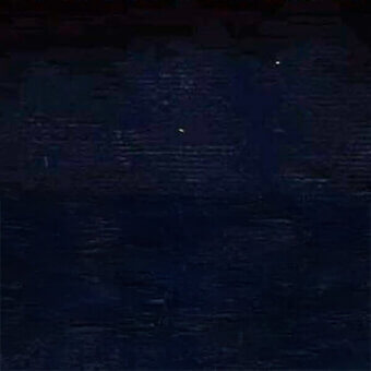 Dark blue and black rippled texture with scattered white dots, creating a monochromatic composition with depth and an unclear organic structure.