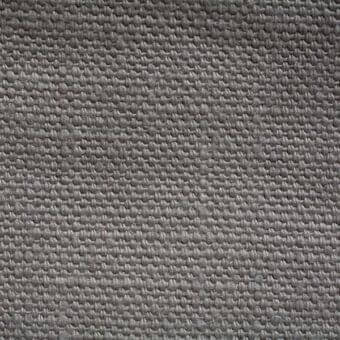 Stone-washed linen fabric sample, muted gray tone, dense weave with heathered effect and visible yarn intersections, matte finish.