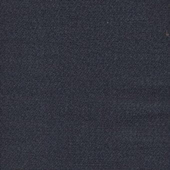Dark gray woven fabric texture with subtle nubbing and sparse light flecks, matte finish, displaying a uniform surface with a dried leaf.