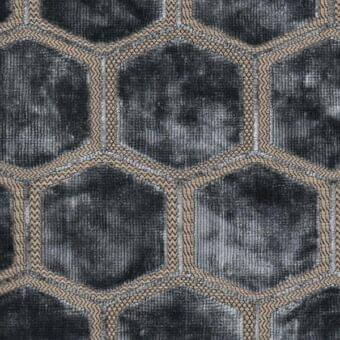 Geometric textile sample with repeating graphite hexagons, outlined in tan and gray woven zigzag, creating a dense, muted fabric pattern.