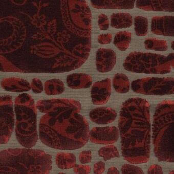 Le Pas des Anges fabric sample, dark red and burgundy floral pattern on light beige, plush velvet texture with overlapping organic shapes.