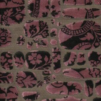 Floral fabric sample, dusty rose and black, with swirling foliage on muted olive green velvet, showcasing baroque-inspired pattern detail.