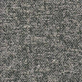 Herringbone fabric sample in gray and off-white tones displays a dense, textured weave with subtle yarn variations and a visible brand label.