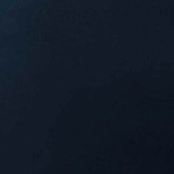 Dark blue-black leather texture with a granular woven finish, evenly lit and minimalist composition emphasizing material quality.