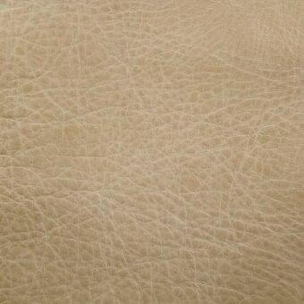 Zebu natural leather texture, light beige, dense grain pattern with irregular bumps and linear creases, matte finish, neutral background.