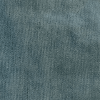 Dusty blue-gray fabric texture with a dense, short pile and subtle tonal variations, presenting a matte, mottled surface appearance.