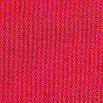 Repeating circular pattern in red and blue tones creates a dense, uniform texture resembling woven fabric with a pixelated visual structure.