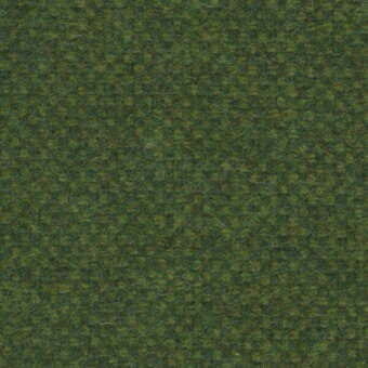 Dense green fiber texture with granular quality, exhibiting subtle tonal variations and scattered yellowish-green highlights under even lighting.