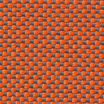 Woven fabric texture with repeating square pattern in orange and gray, displaying a tight grid structure and manufacturer text.