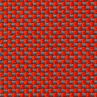 Woven texture sample, orange and gray threads, regular grid pattern with visible text “vescom samar 7052 29”, coarse and slightly raised surface.