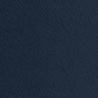 Navy blue granular texture, consistent tone, and diffused lighting showcase a tightly woven or embossed material surface in a studio setting.