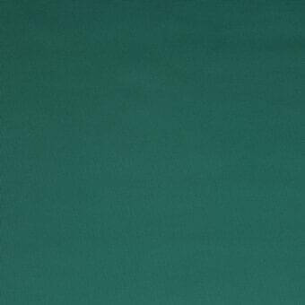Teal woven fabric sample displaying a matte finish and granular texture, with subtle tonal shifts and a darkened bottom edge.