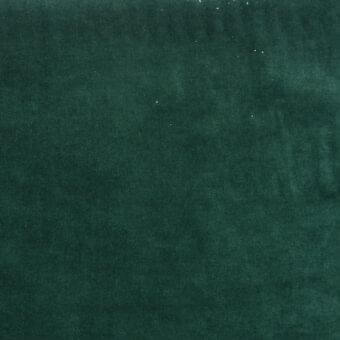 Deep green velvet fabric texture with a dense pile and mottled appearance, displaying a matte finish and subtle color variations.