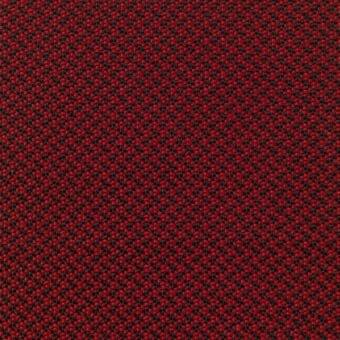 Red fabric texture with a repeating grid of small black and red circles, woven with a matte finish and saturated tone.
